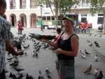 Corn in hand brings pigeons to arm.JPG