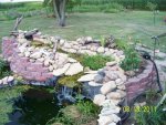 Replaced flat rocks around edge of waterfall, planted some of back side of waterfall.JPG